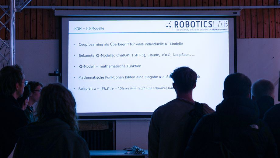 Schülerinnen und Schüler nehmen an einem Workshop teil und blicken in Richtung Präsentation.