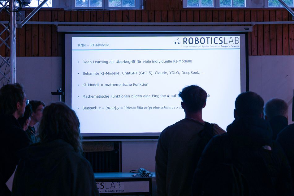 Schülerinnen und Schüler nehmen an einem Workshop teil und blicken in Richtung Präsentation.