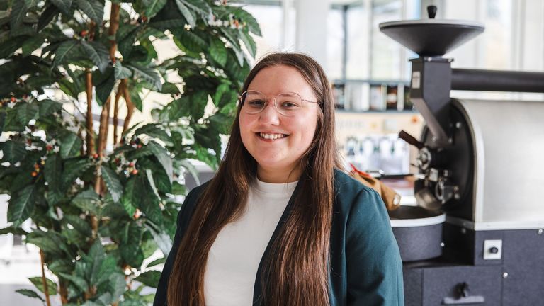 Louisa Hoff, Projektmitarbeiterin der Fachrichtung Lebensmitteltechnik steht vor dem Kaffee-Röster im Technik-Labor