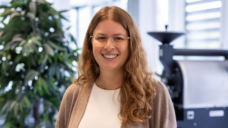 Portraitbild vor dem Kaffeeröster von Shari Piro, Doktorandin in der Fachrichtung Lebensmitteltechnik