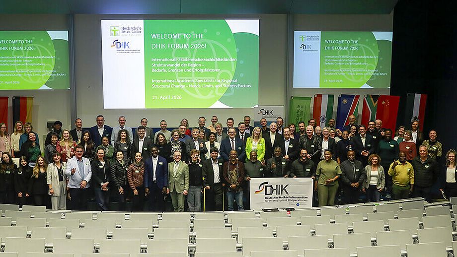 Teilnehmende des DHIK Forums 2026 stehen gemeinsam in einem Hörsaal vor einer Präsentationswand.