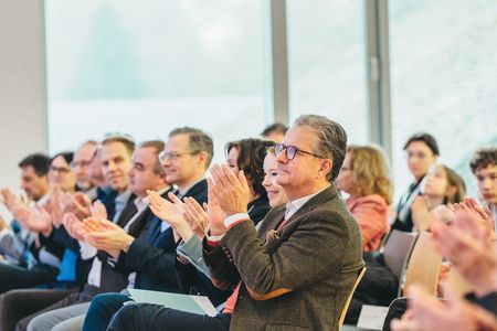 Klatschendes Publikum. Frank Natus sitzt im Vordergund