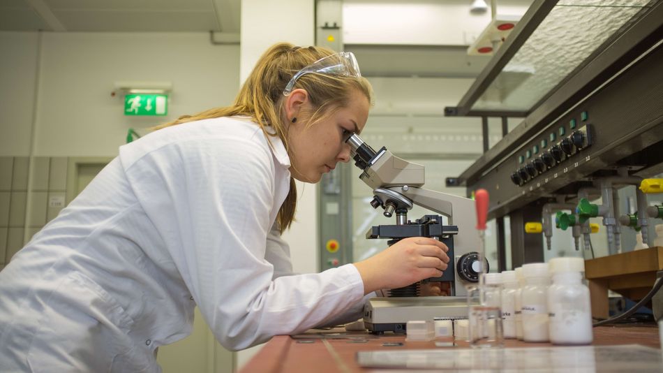 Studentin der Lebensmitteltechnologie bei einer Laboruntersuchung mit einem Mikroskop