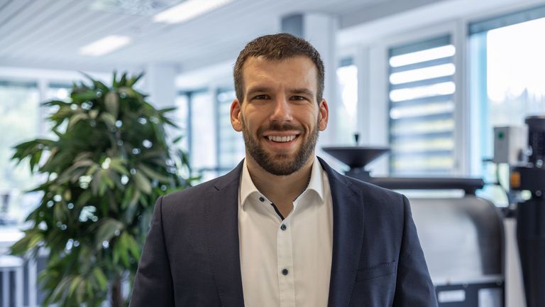 Portraitbild vor dem Kaffeeröster von Michael Féchir, Tandem-Professor in der Fachrichtung Lebensmitteltechnik