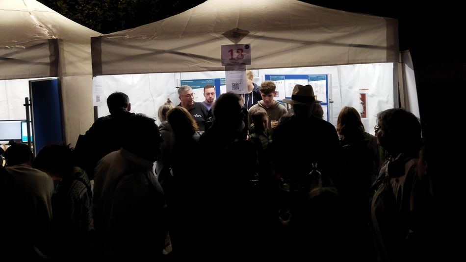 Besucher am Stand der Lebensmitteltechnik City Campus in der Nacht