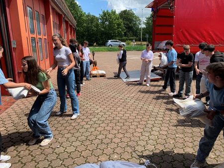 Schüler*innen beim Befüllen von Sandsäcken