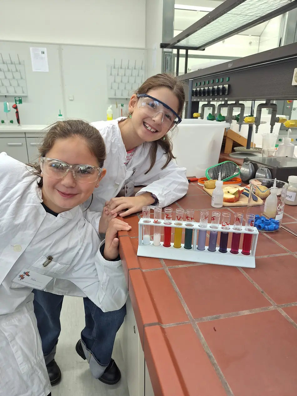 zwei Kinder präsentieren ihre Rotkohl-Farbreihe im Kinderlabor der Lebensmitteltechnik Hochschule Trier